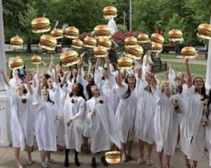 A group of graduates throwing burgers in the air
